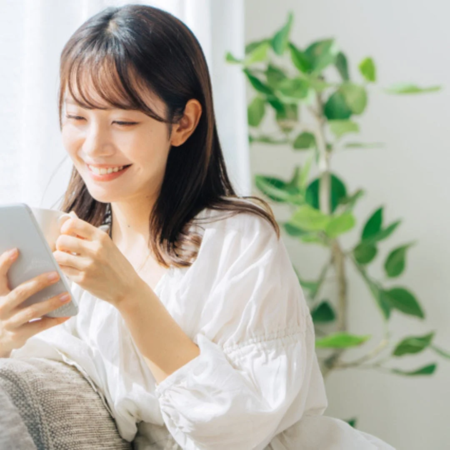 笑顔でスマホを見る女性