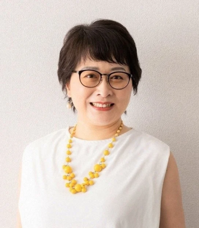 笑顔でカメラを見つめる中高年の女性のポートレートです。