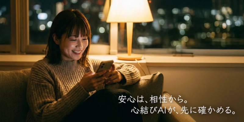 夜の部屋でソファに座りスマホを操作する女性