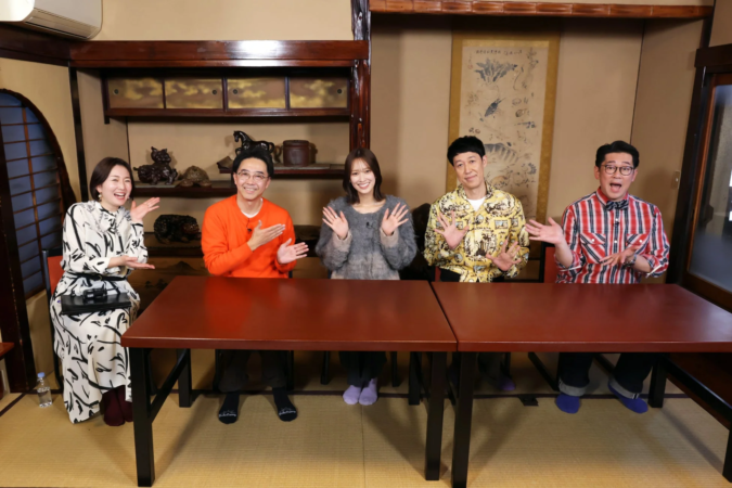 和室で5人の男女がテーブルを囲み、笑顔で手を広げたり身振り手振りを交えたりしている様子。テレビ番組の収録か、和やかなトーク番組の一場面のように見えます。