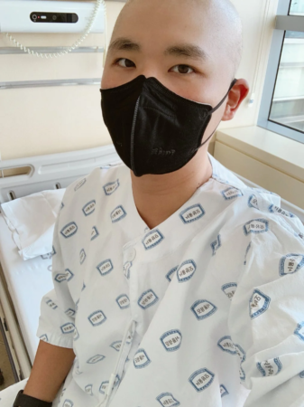 ソウル大学病院の病室でマスクを着けて座る男性