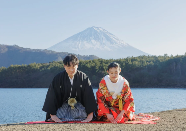富士山と湖を背景に和装で跪くカップル