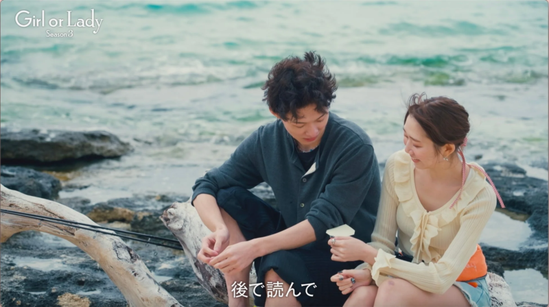 海辺でプレゼントを渡すオダミユさん