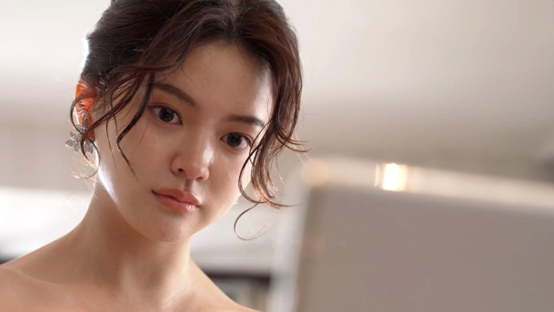 上品な髪型とイヤリングを身につけた美しい女性のクローズアップポートレートです。しっとりとした表情で、柔らかな光に包まれています。