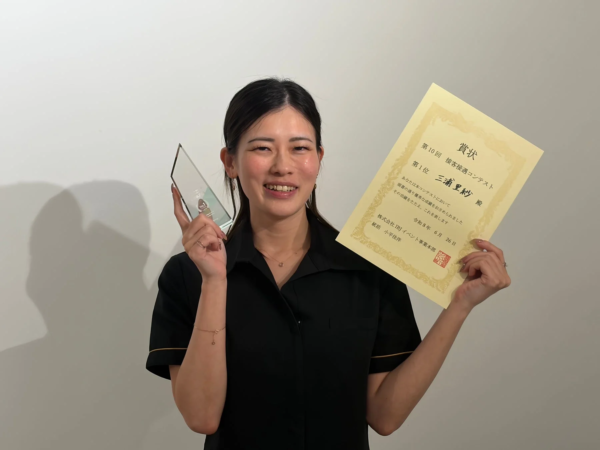 第10回 接客接遇コンテストで優勝し、賞状とトロフィーを手に笑顔を見せる三浦里紗さん