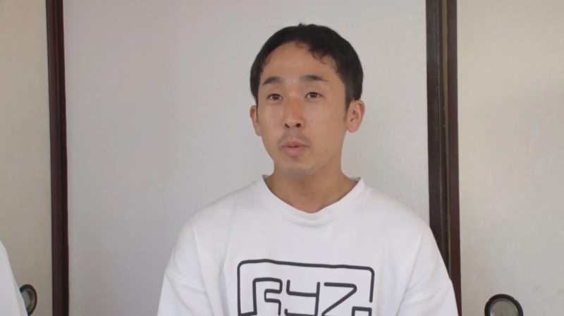 白いスウェットシャツを着た若い男性が話している