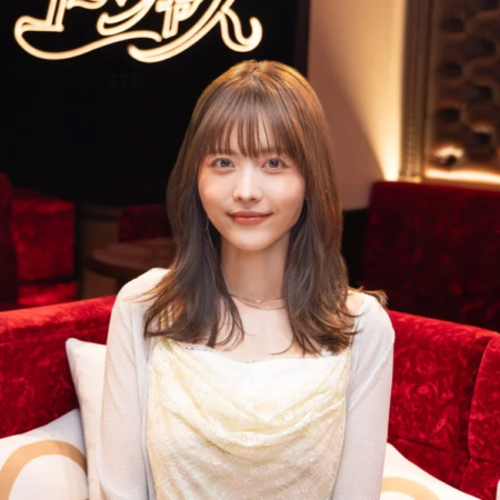 赤いソファに座って優しく微笑む若い女性のポートレート